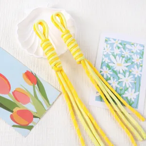 Detailed macro view of yellow hand-woven Roman knot phone lanyards with white flecks