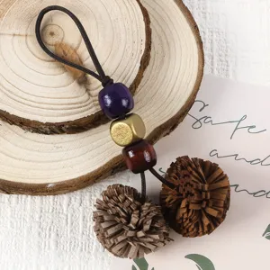 Close-up detail of retro PU leather tassel charm with colorful wooden beads for handbag decoration.