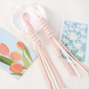 Close-up of hand-woven pink and white Roman knot lanyard with soft cotton texture