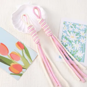Detailed view of handmade pink and white woven Roman knot lanyards with elegant tassels