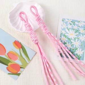 Detailed close-up of pink and white hand-woven Roman knot lanyard for DIY keychains