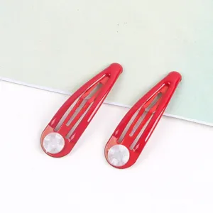 Detailansicht roter Tropfenhaarspangen mit weißen Polstern, glänzendes Haaraccessoire.