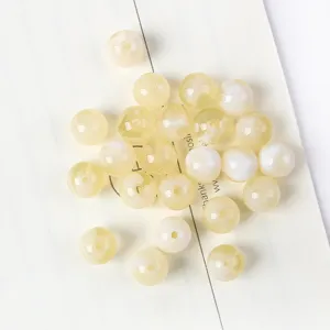 Macro detail of pearlescent yellow acrylic cat-eye beads for DIY jewelry making