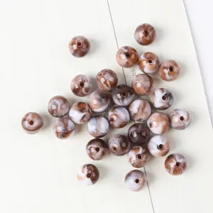 Detail macro view of brown and white marbled acrylic cat eye beads for jewelry making