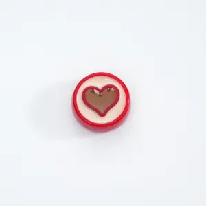 Close-up detail of a red and white acrylic heart bead, perfect for DIY jewelry making.