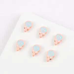 Close-up of cute alloy painted cartoon lollipop beads in pink and blue for DIY jewelry making.
