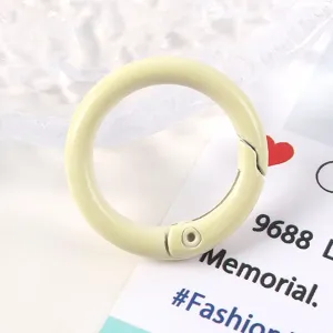 Primer plano de un anillo de resorte crema de 23 mm hecho de aleación de zinc pintada