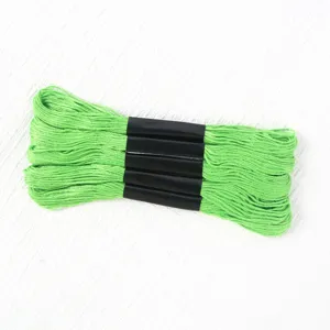 Close-up detail of 5 bundles of bright green polyester embroidery thread with black bands