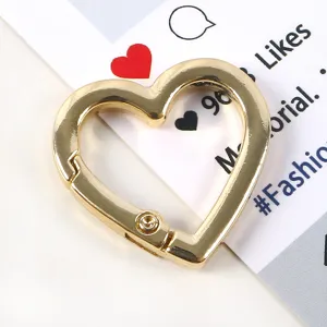 Vista macro dettagliata di un moschettone a molla a forma di cuore dorato per accessori fai-da-te