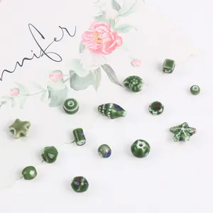 Detailed view of green glazed ceramic beads in various shapes for DIY jewelry accessories