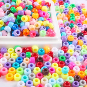 Gros plan de perles poney et perles tonneau en acrylique coloré pour accessoires de bijoux.