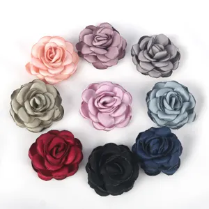 Detailed view of handmade burnt-edge fabric rosebuds in various colors for DIY crafts