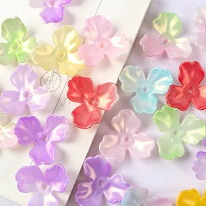 Macro detail of iridescent AB acrylic 3-petal magnolia flower beads for DIY hair jewelry
