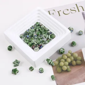 Assorted green kiln-glazed ceramic beads in various shapes for DIY jewelry making.