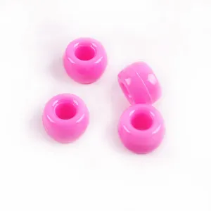 Gros plan de perles en acrylique rose vif, perles barils a grand trou pour creation bijoux.