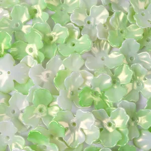 Detail view of iridescent green acrylic three-leaf flower beads for DIY crafts