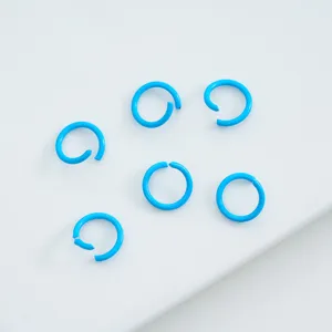 Macro view of light blue painted alloy open jump rings for DIY jewelry.