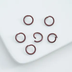 Close-up of reddish-brown painted alloy open jump rings for DIY jewelry making.