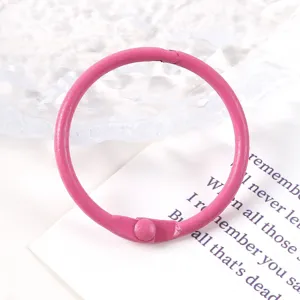 Primer plano de una anilla de metal rosa de 30mm para organizar hojas sueltas DIY