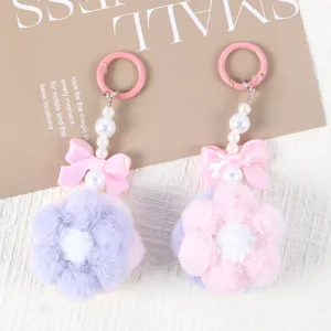 Close-up of handmade pink and purple plush flower pendants with pearl beads