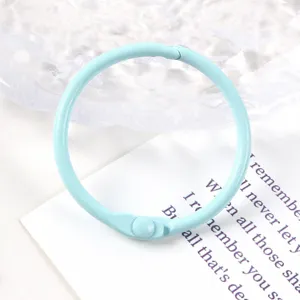 Primer plano de un anillo de encuadernación de metal pintado azul claro de 30 mm para bricolaje.