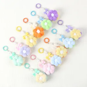 Collection of colorful handmade plush flower pom-pom keychains with beaded charms and bows
