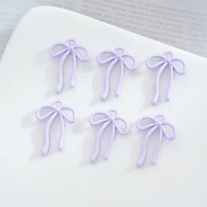 Gros-plan de pendentifs charmes nœud ruban en alliage violet clair pour bijoux faits main.