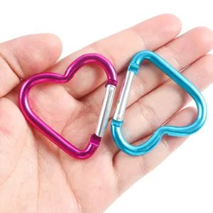 Détail en gros plan de mousquetons mignons en forme de cœur rose et bleu pour porte-clés DIY.