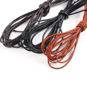 Vista detallada de cordones de cuero redondos en negro y marrón para joyería DIY.