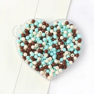 Récipient en forme de cœur rempli de perles acryliques mélangées cyan et blanc
