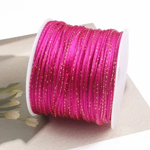 Close-up view of hot pink metallic jade cord neatly wound on a spool for DIY crafting.