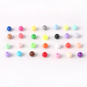Vue rapprochée de 42 perles rondes en acrylique coloré pour créer des bijoux faits main