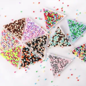 Vue en plongée de perles rondes en acrylique colorées pour la création de bijoux DIY.