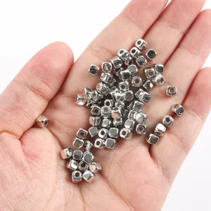 Detail shot of silver CCB square spacer beads held in hand, perfect for DIY jewelry making.