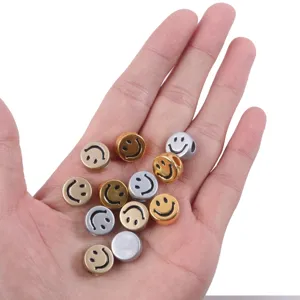 Close-up of gold and silver metallic smiley face acrylic beads for DIY jewelry bracelet making