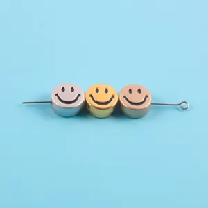 Detailed view of metallic gold and silver smiley face flat beads for DIY jewelry making accessories.