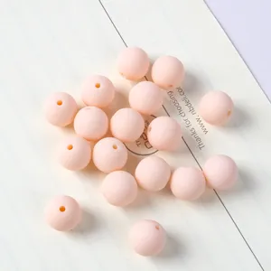 Dettaglio di perle macaron in acrilico opaco color pesca per progetti di gioielli fai da te