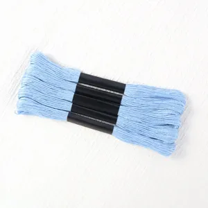 Close-up of light blue 6-strand polyester embroidery thread skeins for cross-stitch.