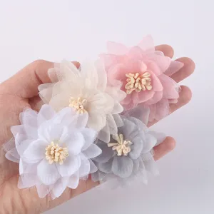 Detailed view of handmade chiffon and organza flowers in soft pink, white, and grey.