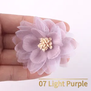 Detail of hand holding a light purple handmade chiffon organza flower accessory