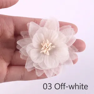 Close-up of a delicate off-white chiffon and organza handmade fabric flower accessory.
