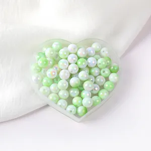 Close-up detail of glossy green AB acrylic round beads in heart tray for DIY jewelry and phone chain