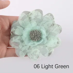 Primo piano dettagliato di un fiore in organza e pizzo verde chiaro per accessori capelli.