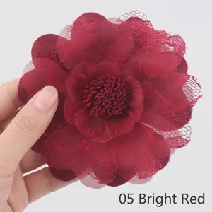 Dettaglio di un fiore in tessuto organza rosso scuro con petali in pizzo delicato