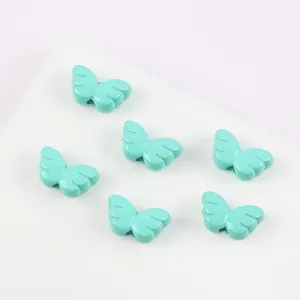 Macro-weergave van zes turquoise vlindervleugelkralen voor het maken van DIY-sieraden