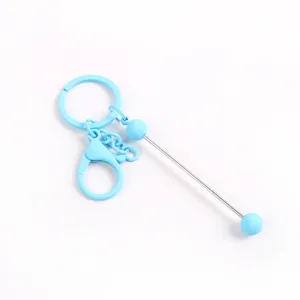 Detalle de llavero DIY azul claro con varilla para cuentas y cierre de mosquetón para bolsos.