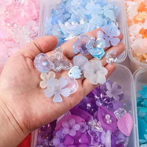 Detailed view of frosted AB color acrylic flower and butterfly beads held in a hand