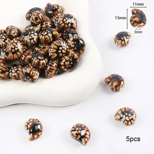 Vista detallada de cuentas de cerámica de caracola marrón para joyería DIY