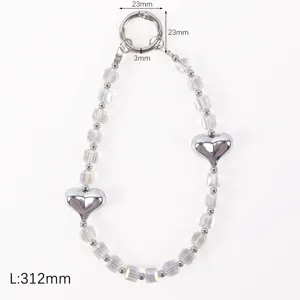 Crystal phone charm strap with metal heart pendants and clear beads for wrist decoration.