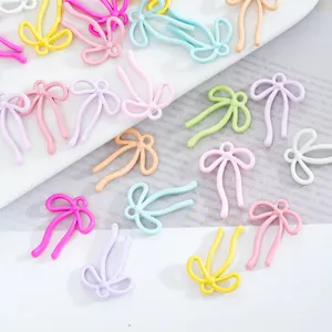 Gros plan détaillé de charms ruban nœud en alliage coloré, parfaits pour la bijouterie DIY.